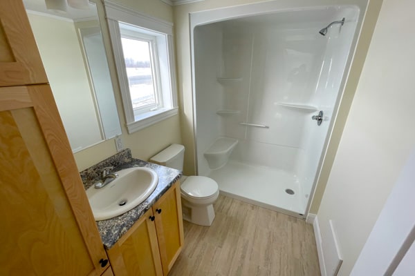Bathroom with shower, toilet, sink, and storage